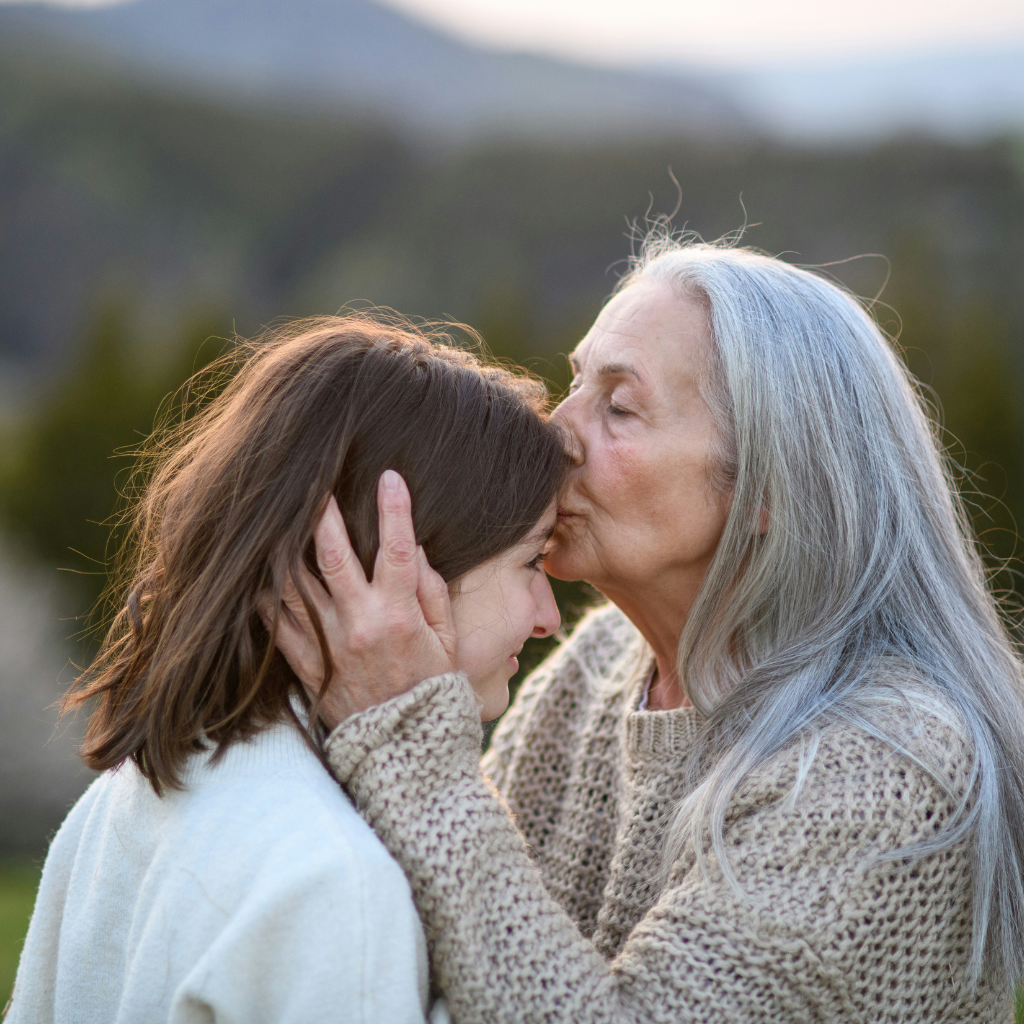 A Better Future older woman kissing young woman on forehead